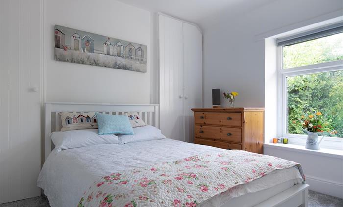 The double bedroom is bright and looks out towards the garden and summerhouse.  There is plenty of storage and a large mirror and ladder shelf unit no